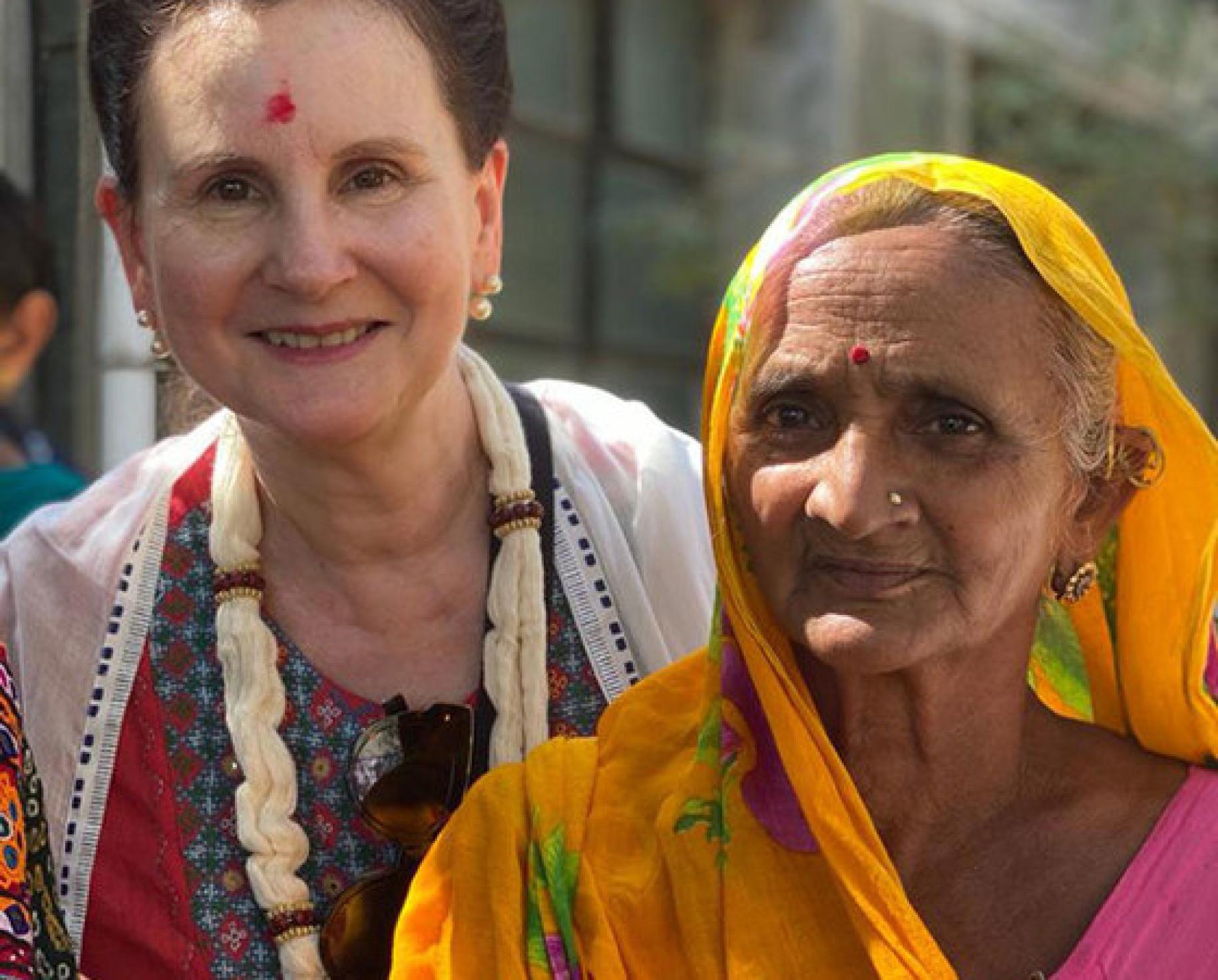 Renata Dessallien (izquierda), la Coordinadora Residente de las Naciones Unidas en la India, junto a una mujer con un velo naranja.