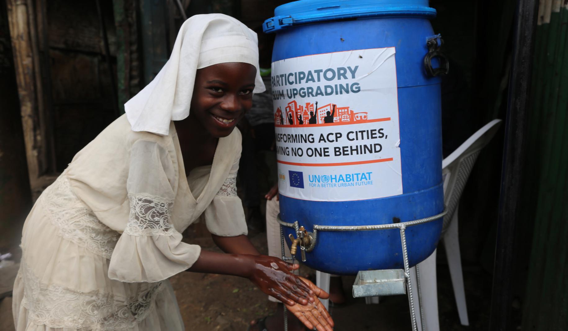 امرأة في أحد مرافق غسل الأيدي التي أنشأها موئل الأمم المتحدة في حي ماثاري الفقير في نيروبي، كينيا.