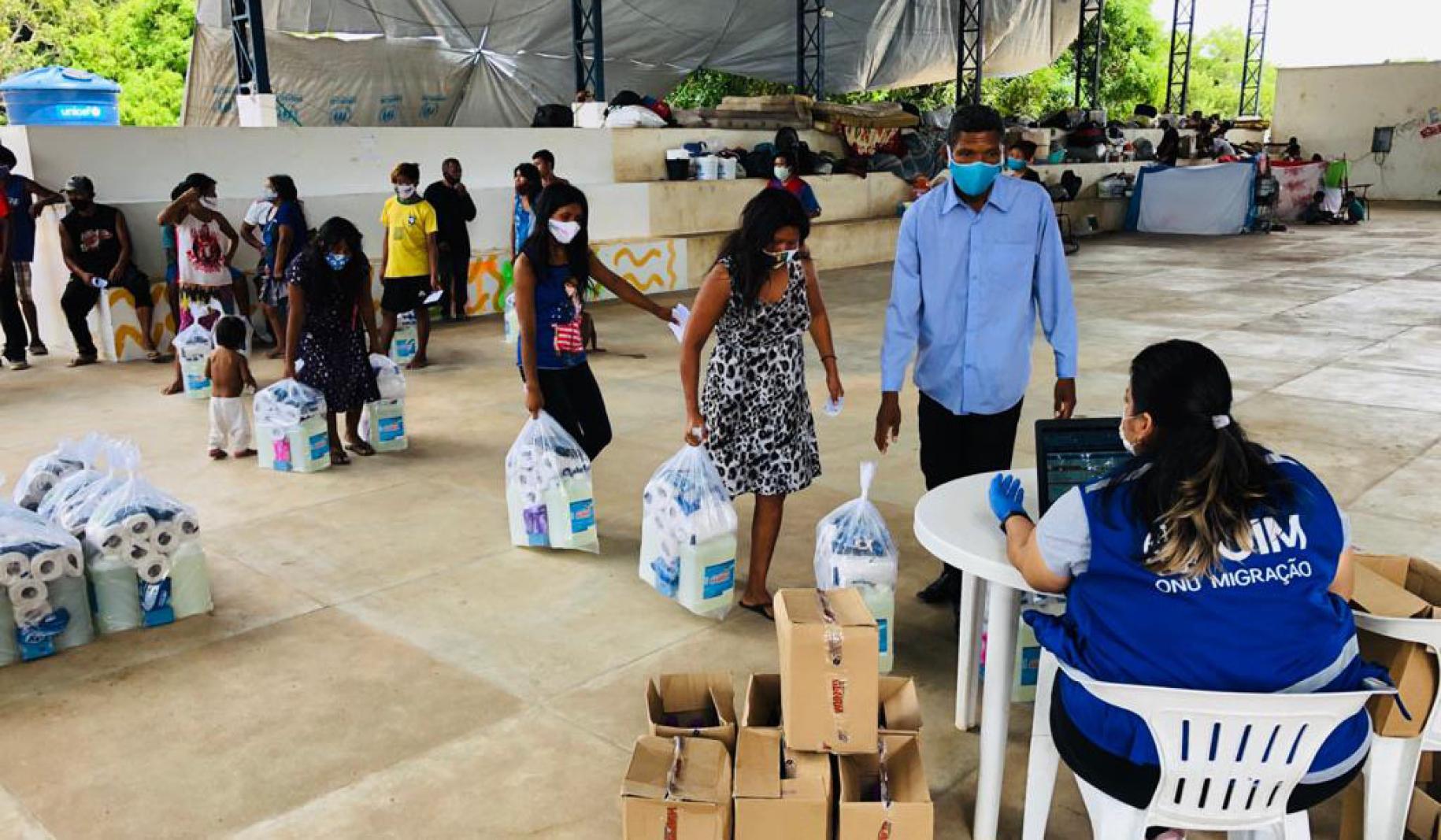 People at a local facility obtain essential supplies provided by IOM.