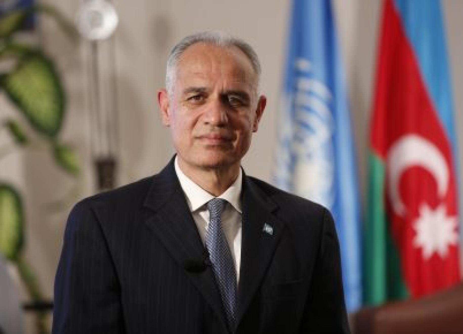 Official photo of the Resident Coordinator, Ghulam M, Isaczai, in front of the UN and Azerbaijan flag. 