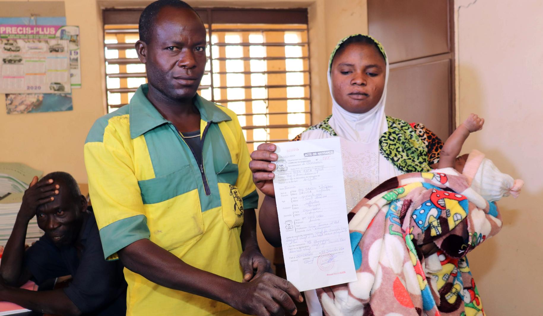 Tras un arduo proceso, Safiatou y su marido Idrissou reciben el certificado de nacimiento de su infante recién nacido.