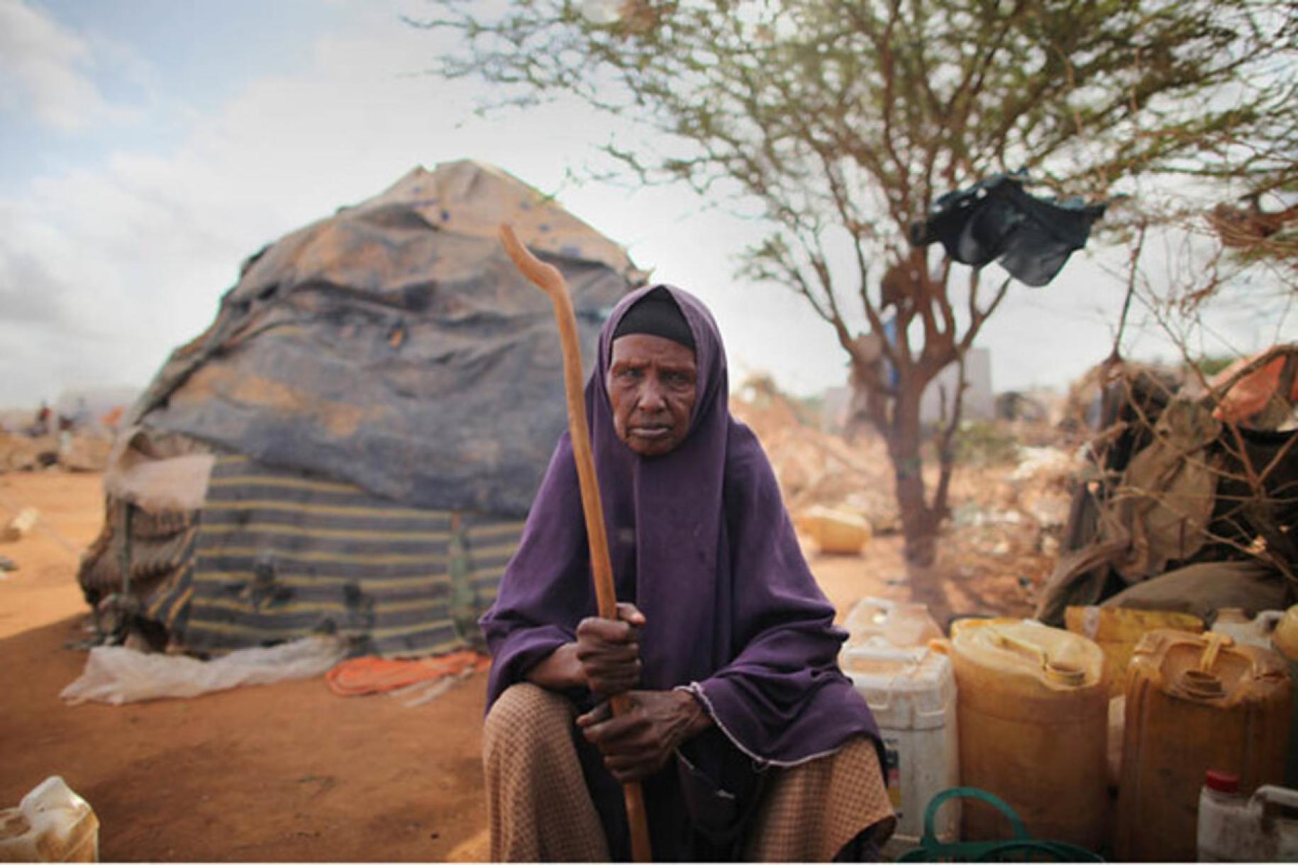 Older resident living in the Internally Displaced People camp sits outside a tent.