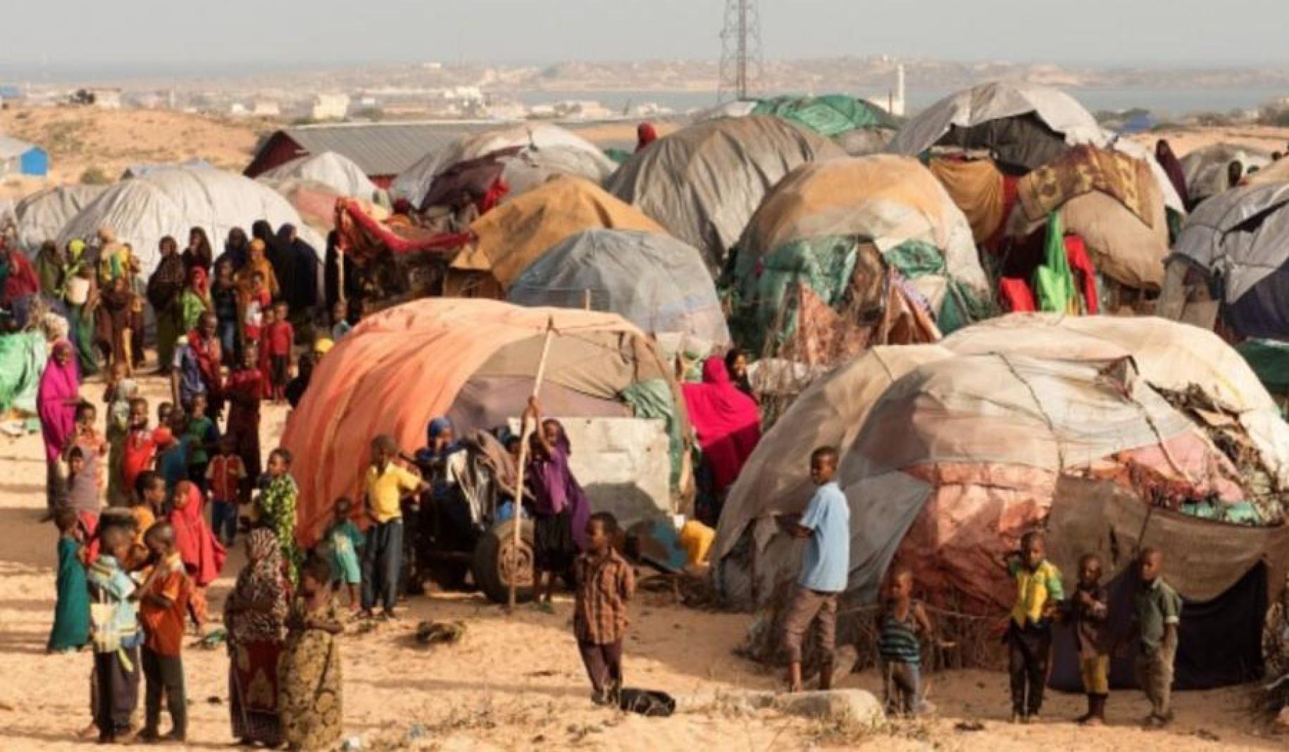 Vista panorámica de un campamento para desplazados internos. Hay gran cantidad de carpas y muchas personas, incluyendo hombres, mujeres, niños y niñas.
