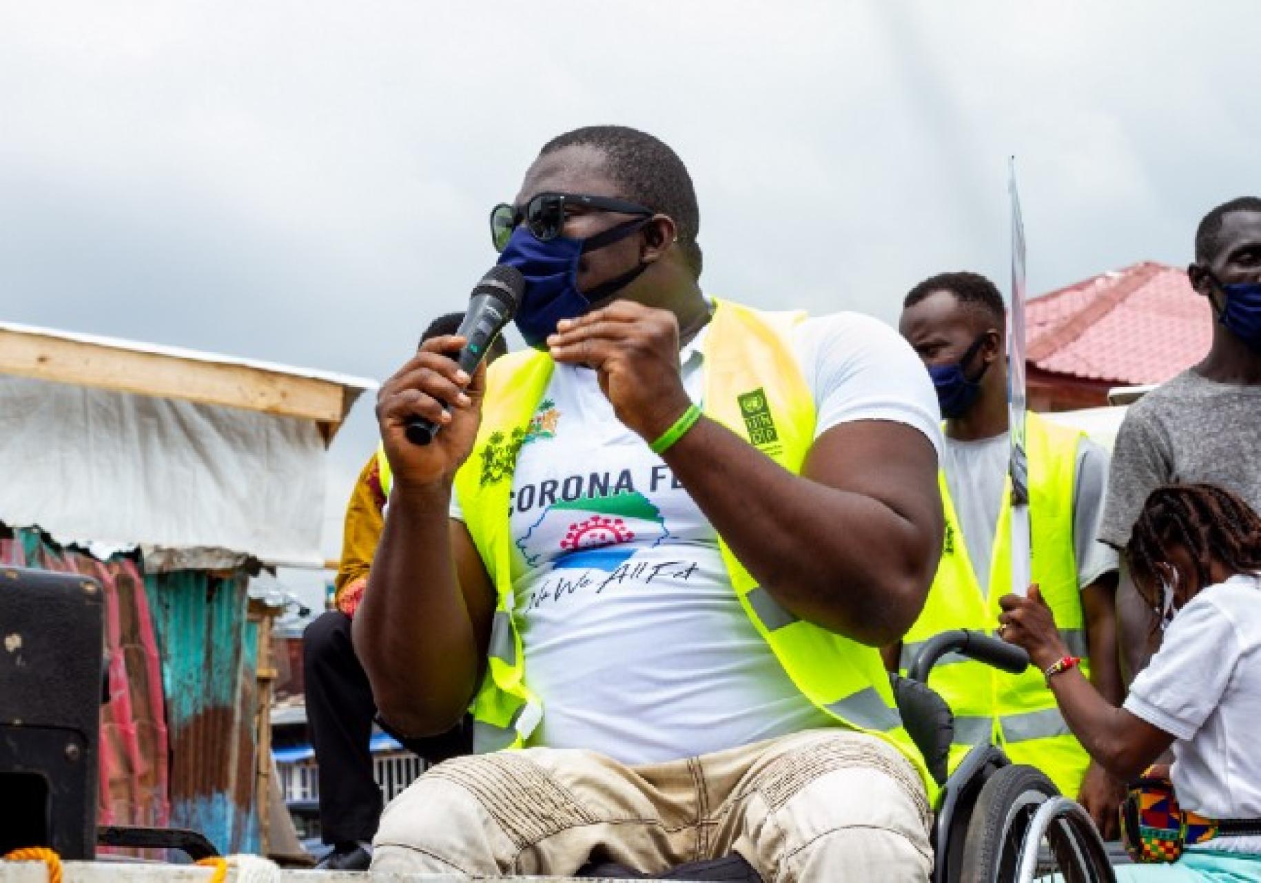 جورج ويندهام، الحاصل على ميدالية بارالمبية من سيراليون، على كرسيه المتحرك يخاطب الجمهور