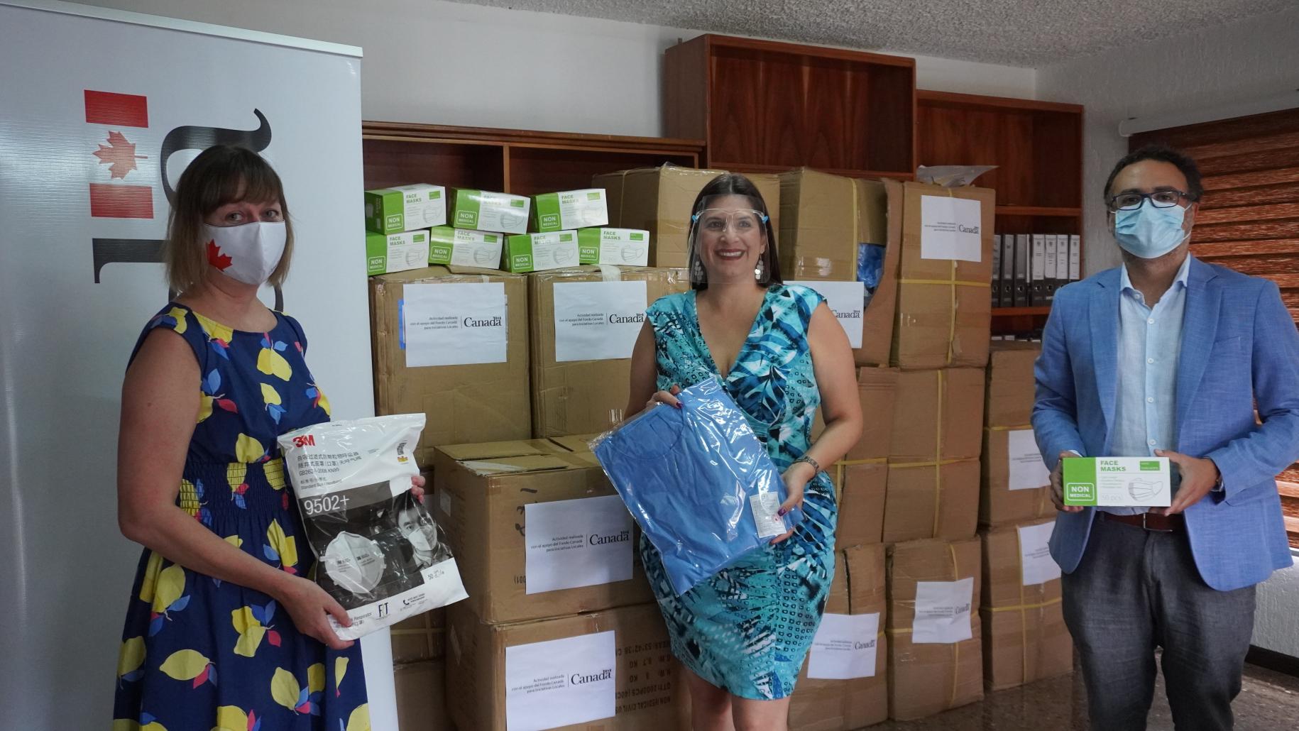 Personal de la ONU sostiene muestras de los suministros esenciales donados al país.