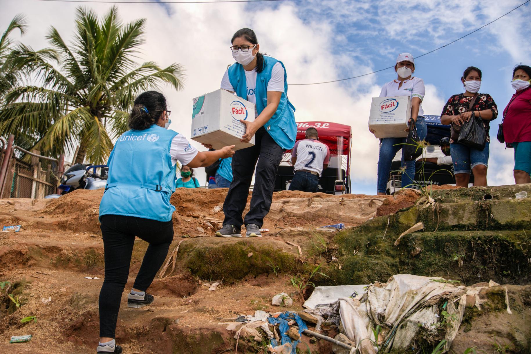 UN Staff carry boxes of supplies to communities in remote areas of Peru.