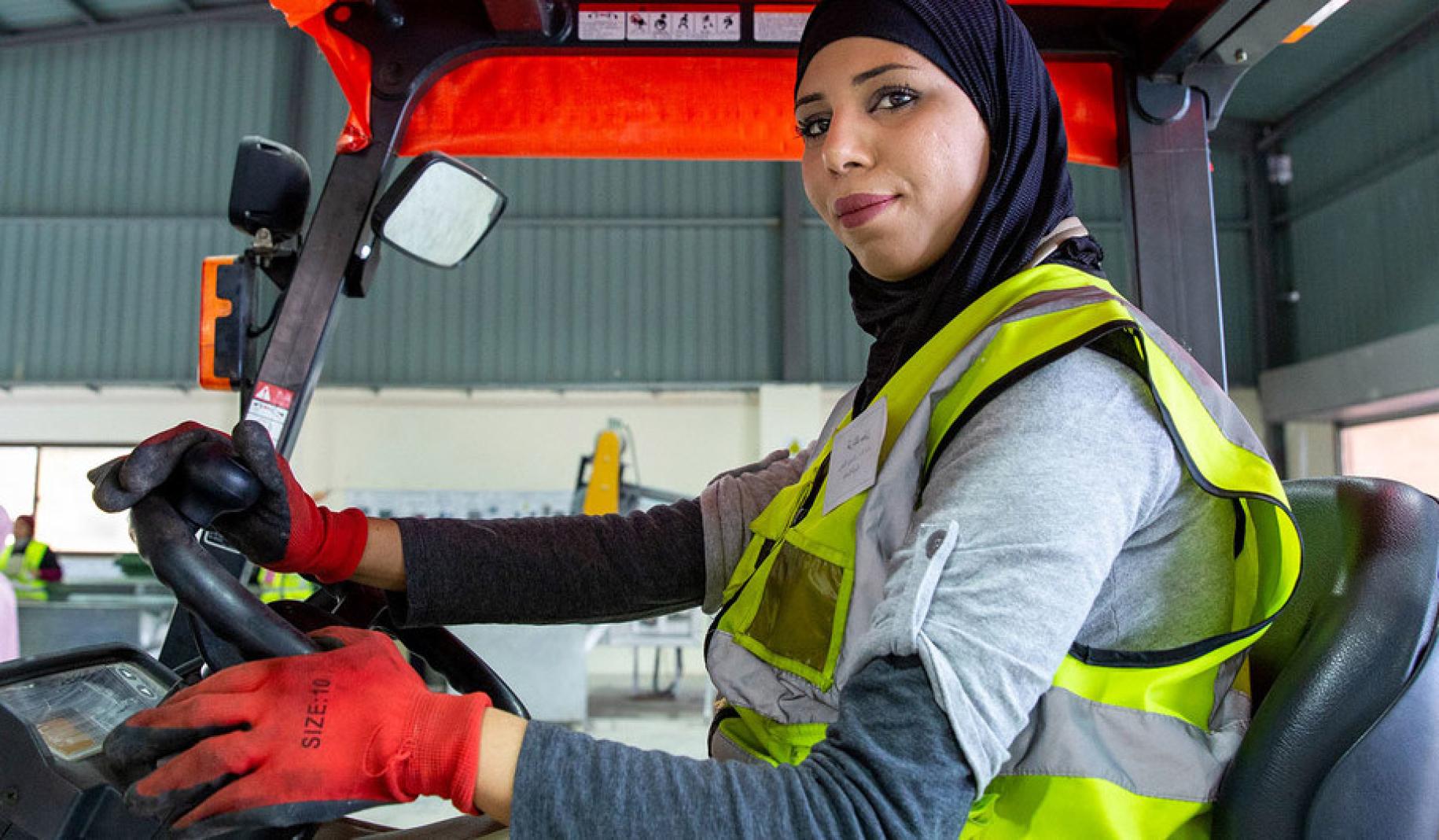 A woman drives a forklift truck at the recycling plant where she works in Northern Shouneh, Jordan.
