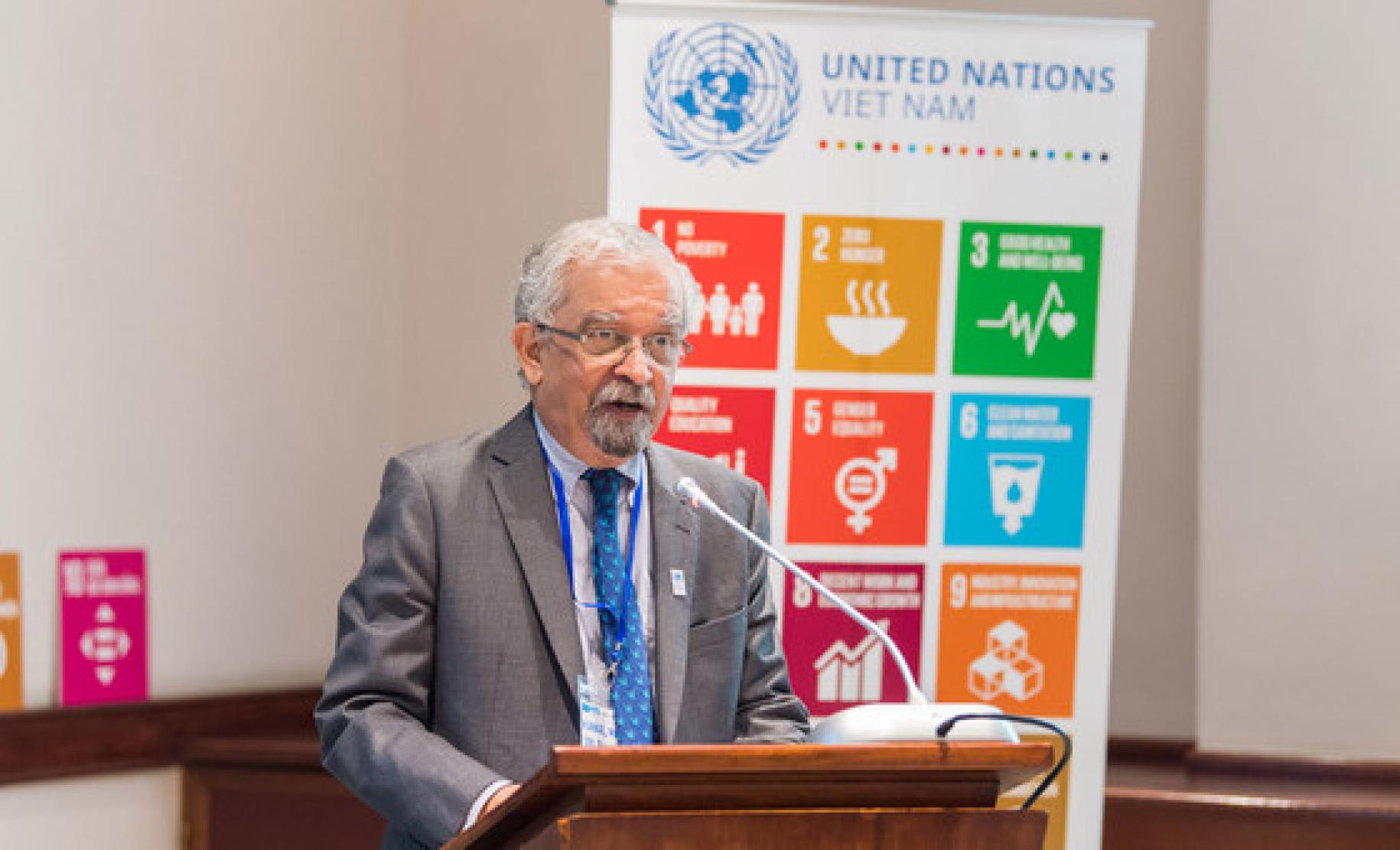Kamal Malhotra the UN Resident Coordinator in Viet Nam is shown speaking at a podium.