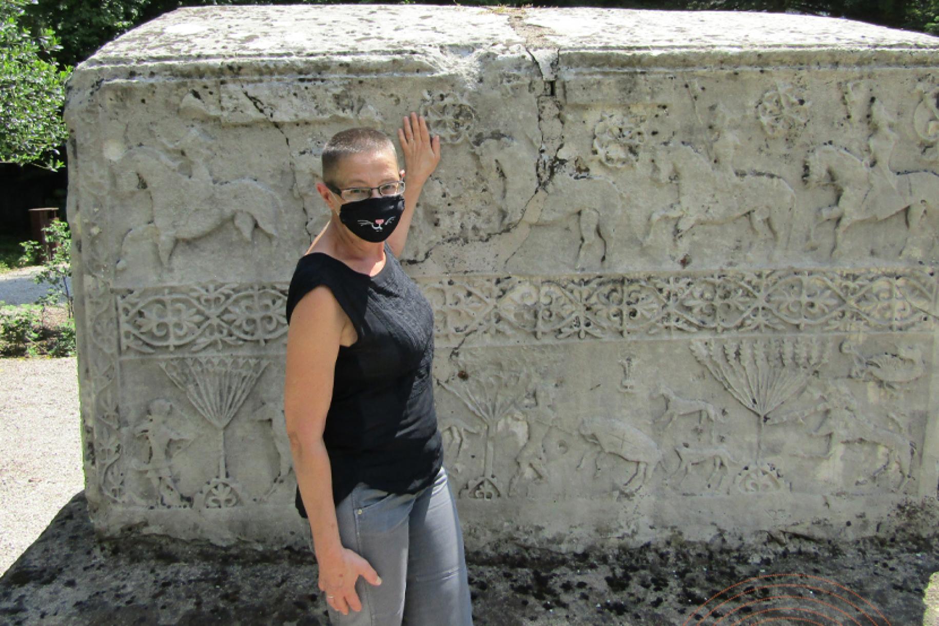Andrea Dautovic se encuentra junto a una gran escultura encajonada en el Museo Nacional de Bosnia y Herzegovina con una mascarilla facial.
