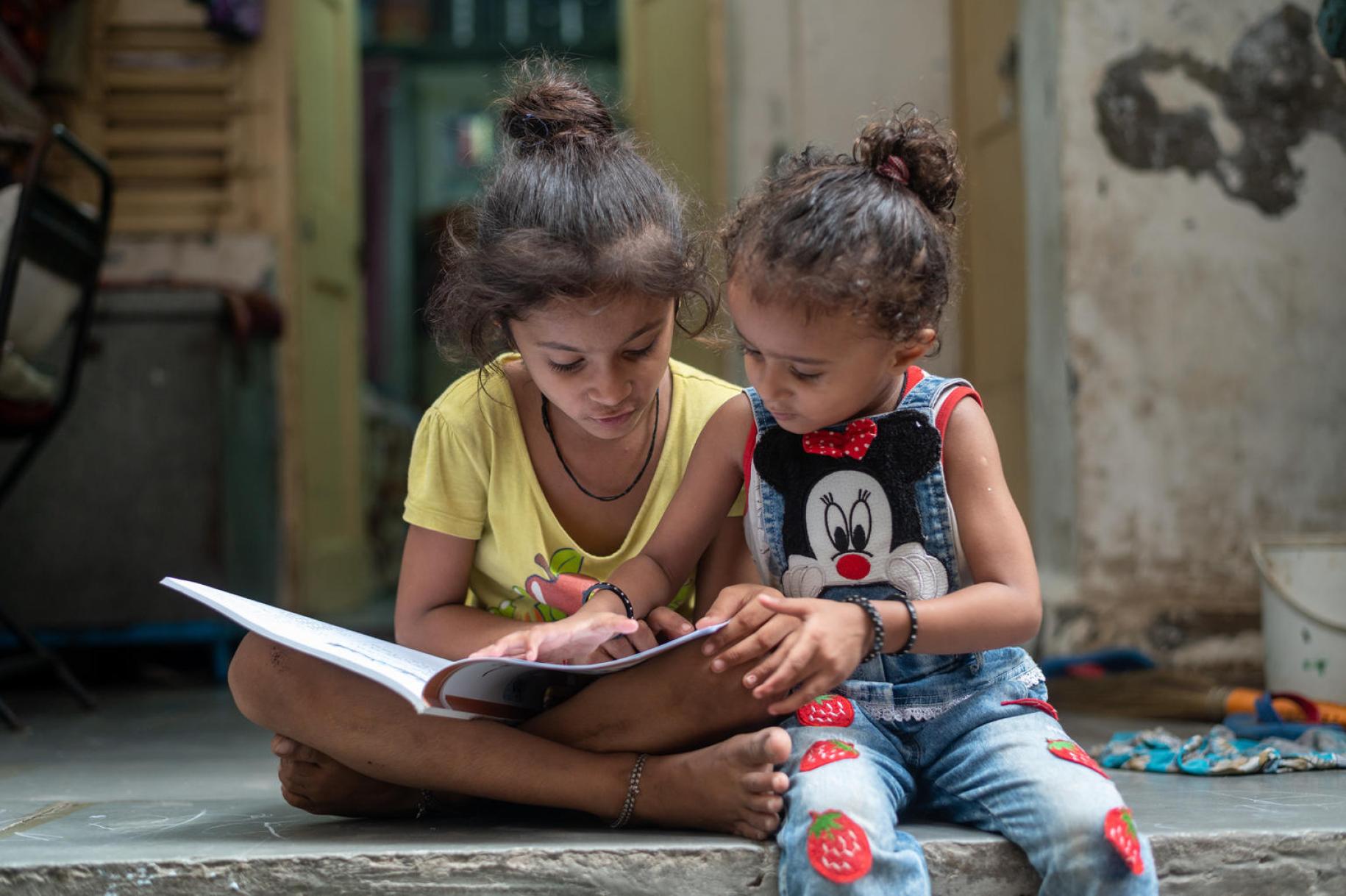 فتاة صغيرة وشقيقتها تدرسان في المنزل أثناء الإغلاق الشامل.