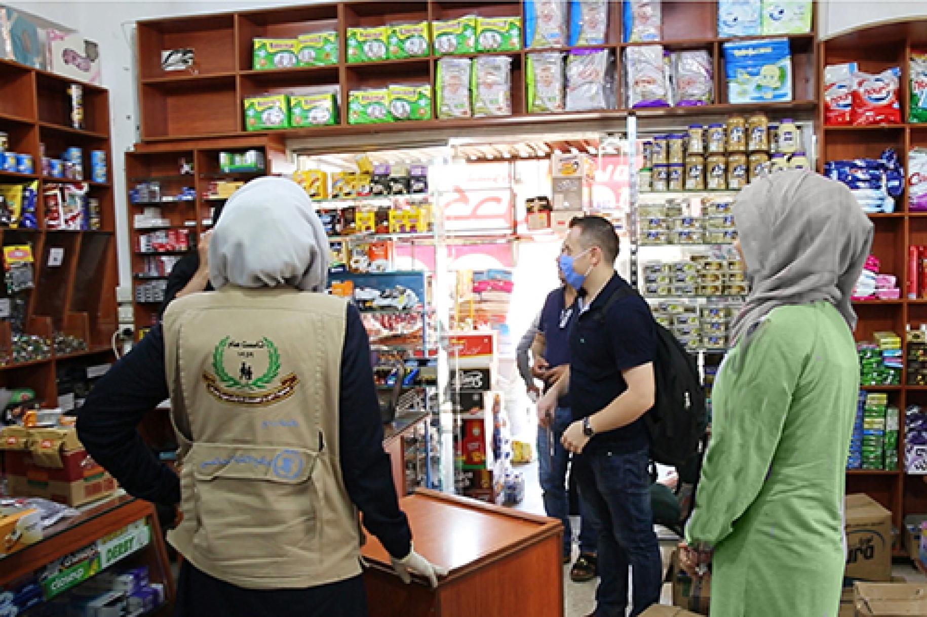 People are shown at a local store using, where the e-vouchers are accepted.