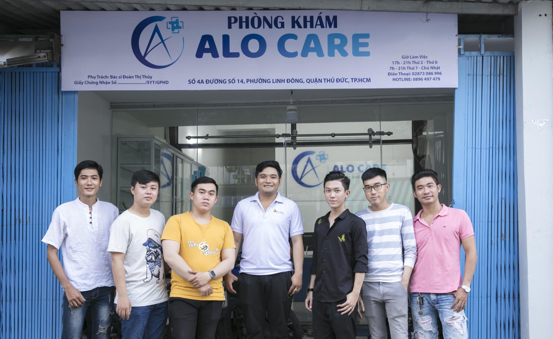 Minh Thuan with his self-help group stand proudly in front of the entrance of Alo Care.