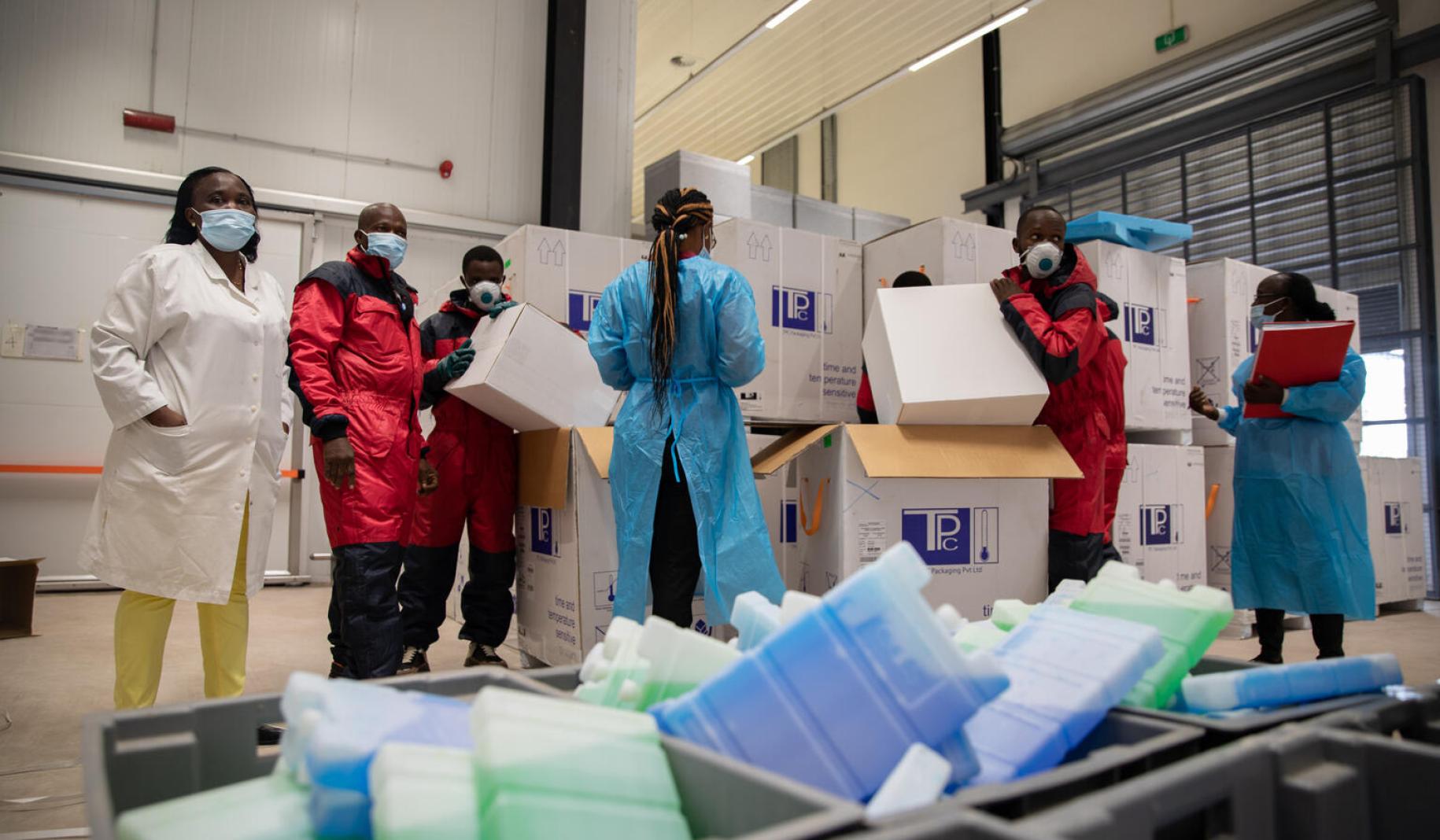 Cold chain staff unpack the COVID-19 vaccines for storage in the cold room.