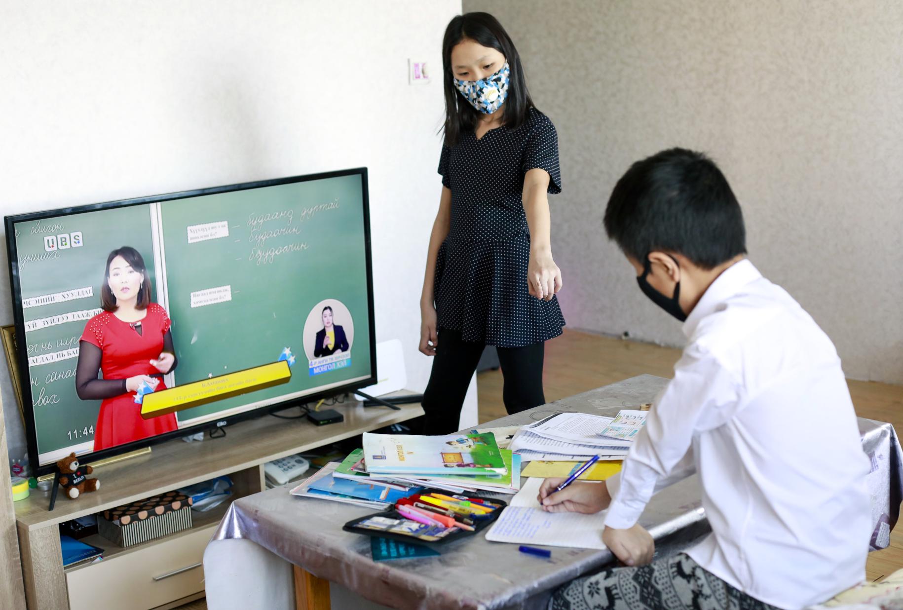 Siblings are attending tele-classes at home in Mongolia