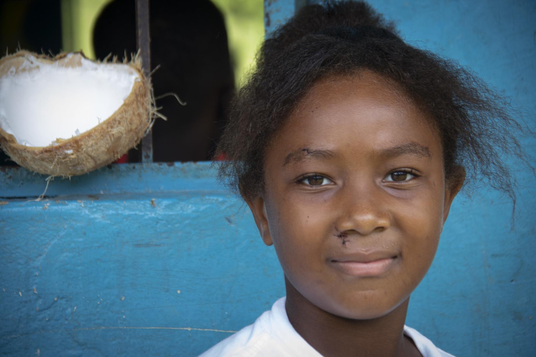 Portrait en gros plan d'une jeune écolière souriant face caméra. 