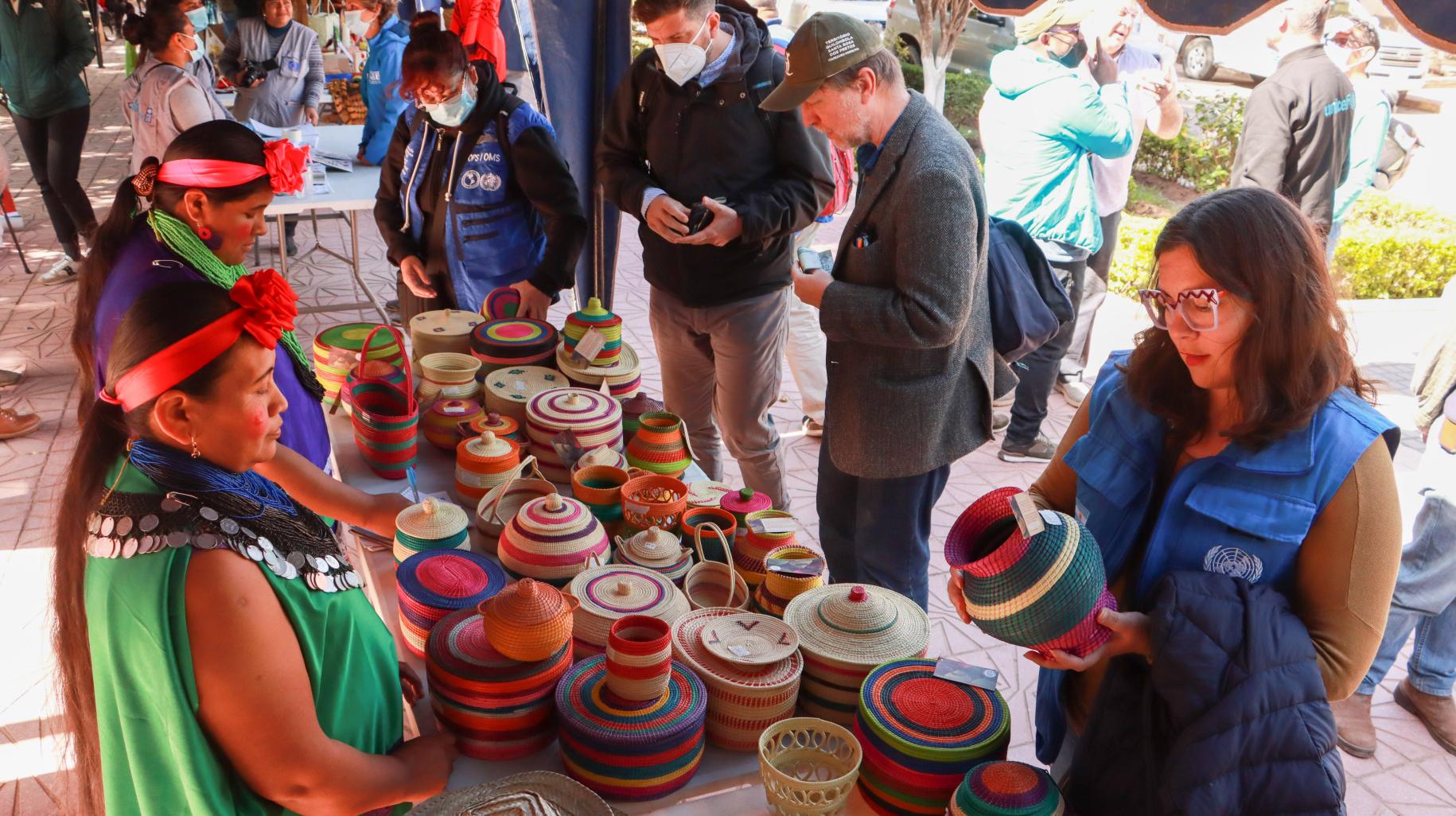 La delegación conversa con artesanas guaranís del Municipio de Entre Ríos en Bolivia, que han encontrado en la producción y venta de artesanía con hoja de palma una puerta de resiliencia ante el impacto del cambio climático.
