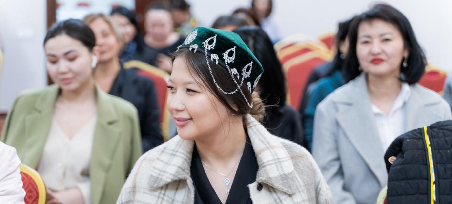 Close-up of a girl wearing a traditional Kazakh headdress.