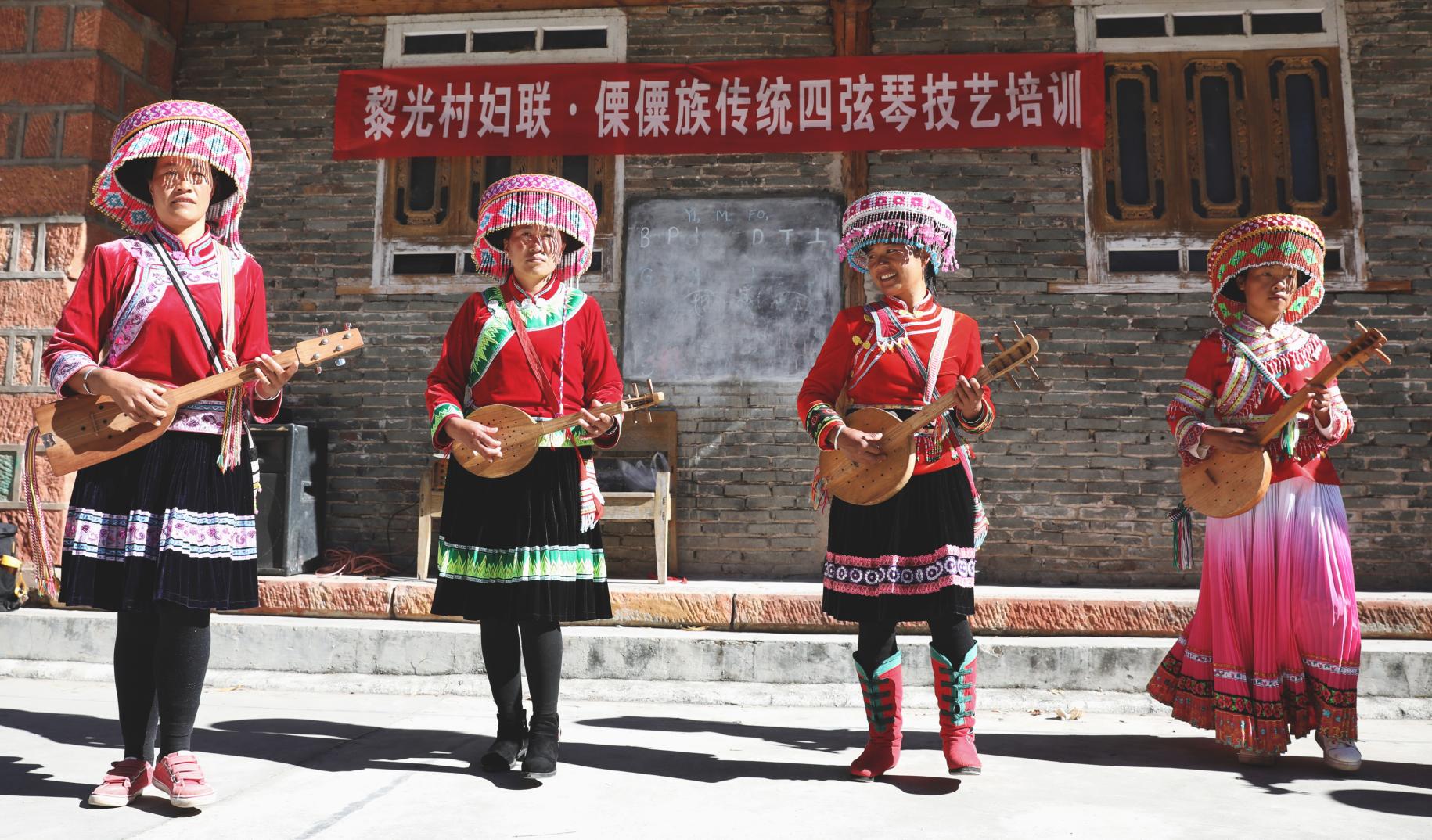 Quatre femmes issues de minorités ethniques en Chine jouent du Qiben, un instrument de musique traditionnel, dans le village de Liguang. 