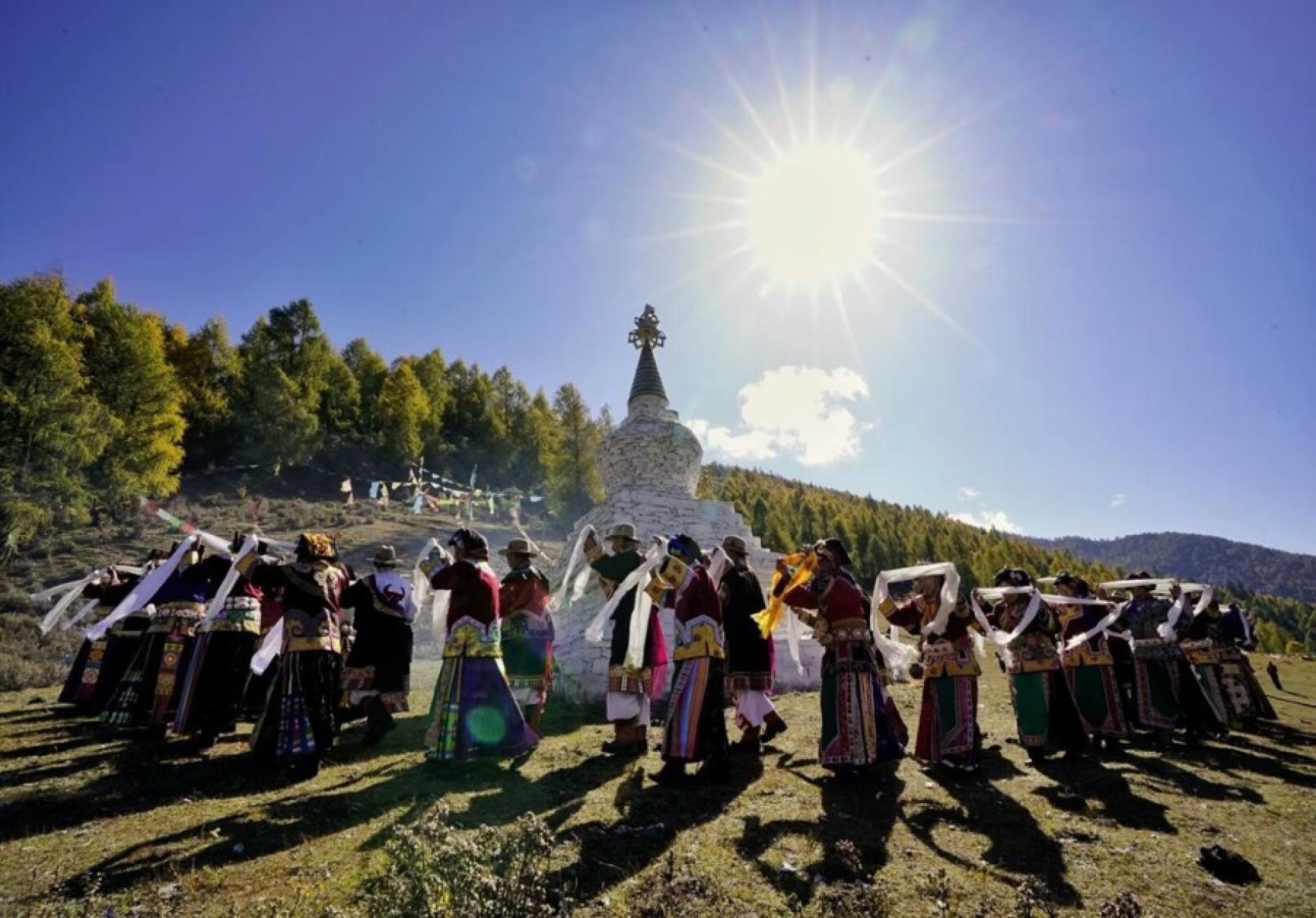 Mujeres de la minoría étnica bailando al sol, participando en la ceremonia del pueblo de Jiajin.