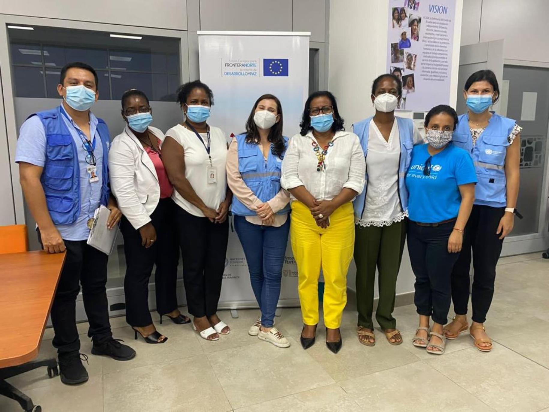 En Équateur, huit personnes portant des masques de protection respiratoires posent devant la caméra, côte à côte.