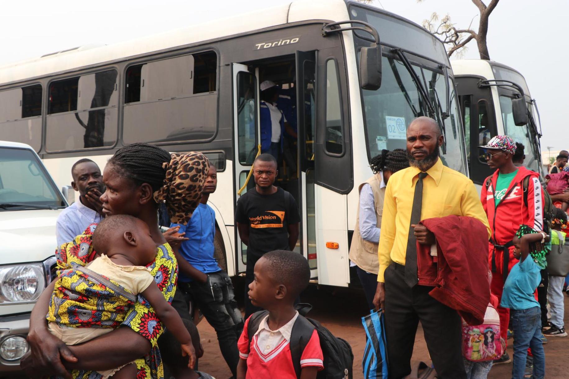 En Angola, des réfugiés, hommes, femmes et enfants arrivent les uns après les autres devant des bus qui les attendent pour les conduire jusqu’à la frontière avec la République démocratique du Congo.