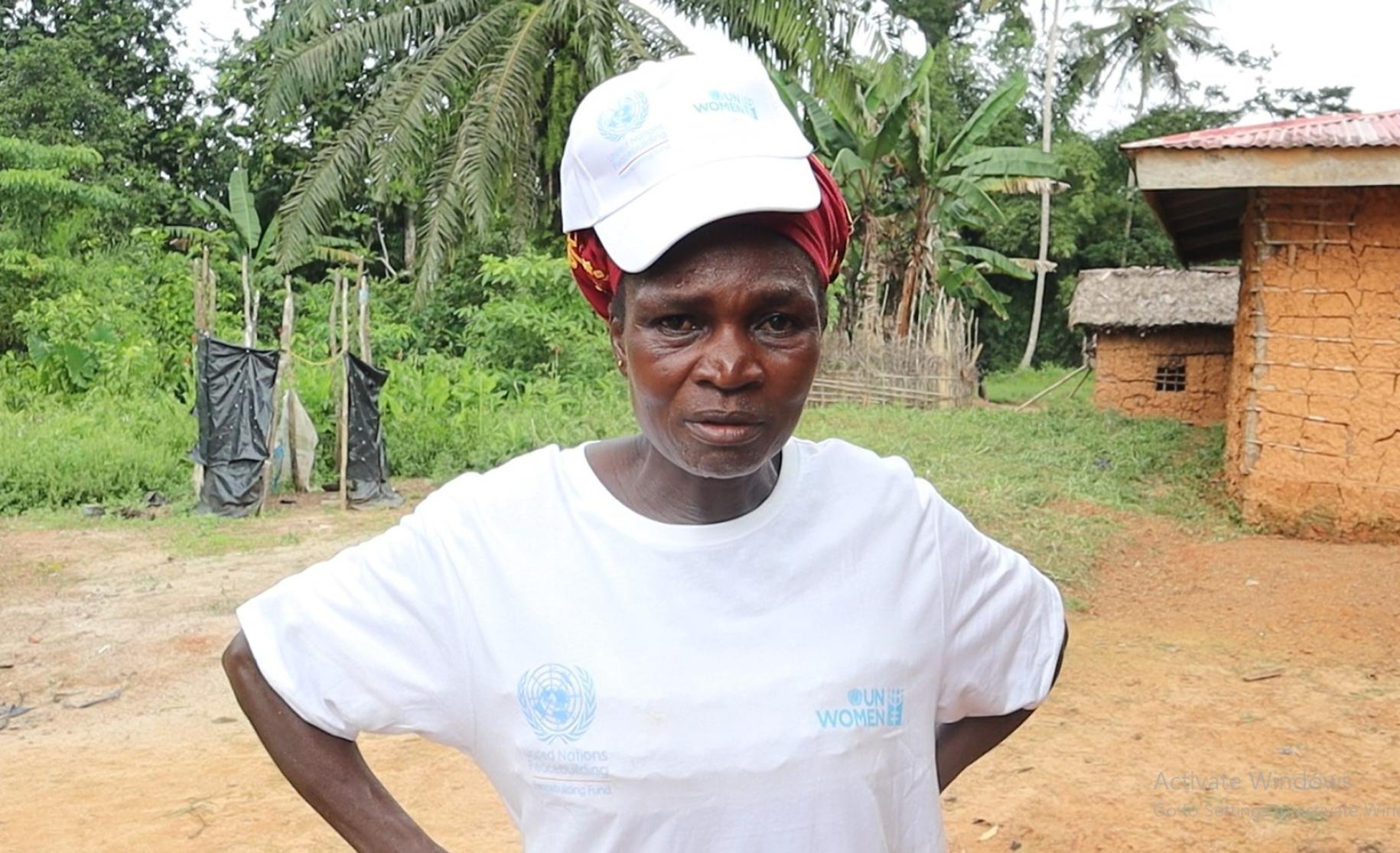 صورة لامرأة ترتدي قميصًا وقبعة بيضاء من هيئة الأمم المتحدة للمرأة وتنظر للكاميرا.