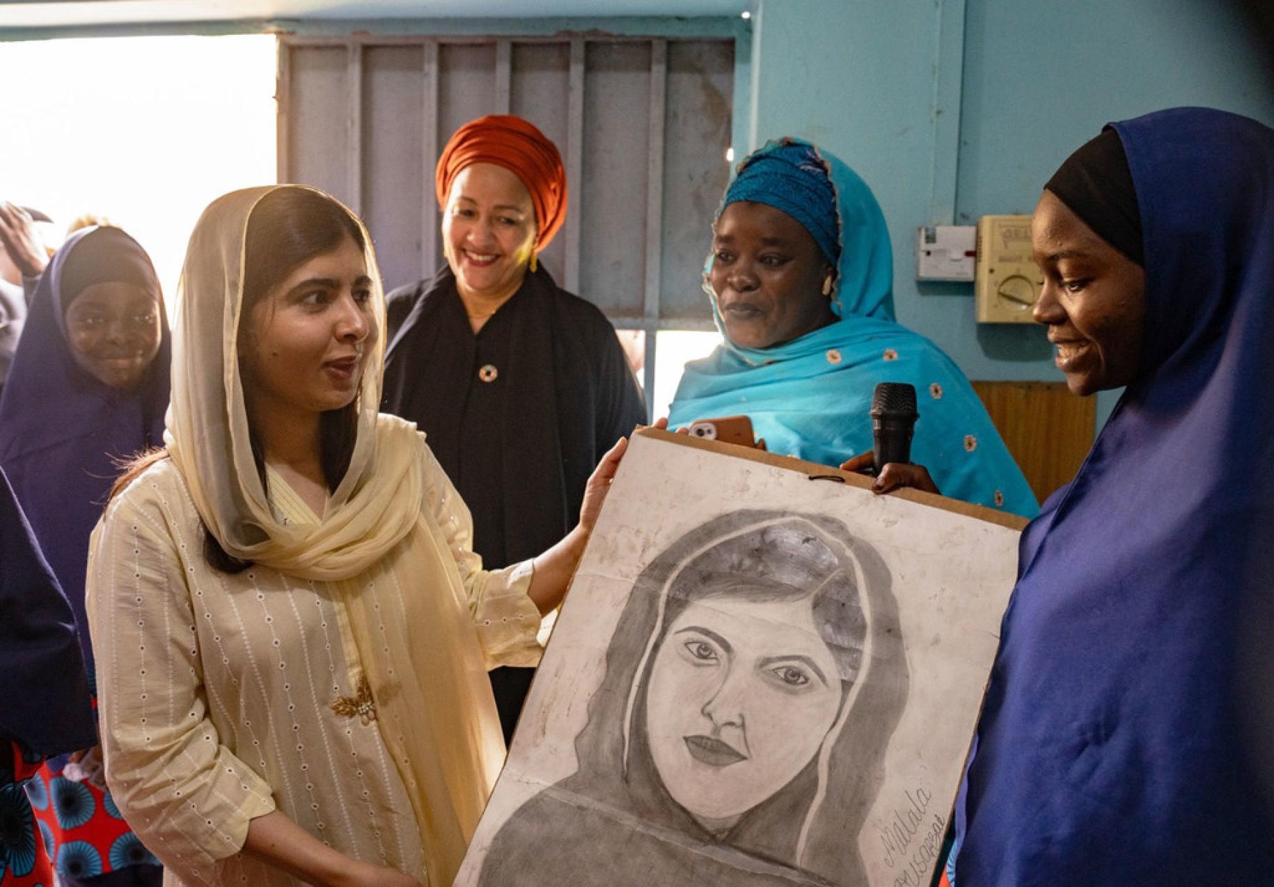 Malala Yousafzai receives a photo as Deputy Secretary-General Amina J. Mohammed looks on