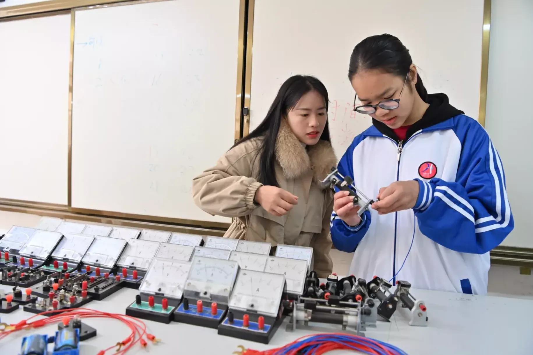 广西天等县华隆中学学生韦李敏（右）和老师刘玉萍在做电阻实验（2023年12月27日摄）。