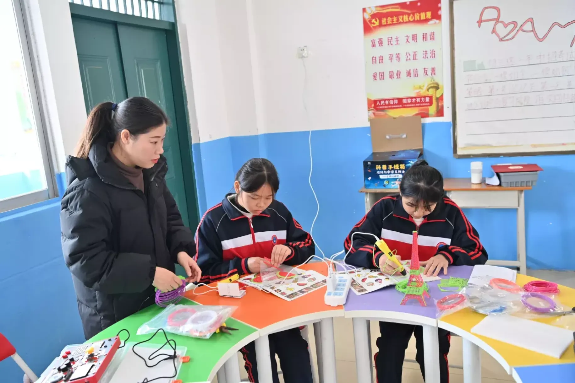 广西天等县仕民实验学校学生许子瑜（中）、农彩杭（右）在老师的指导下制作3D模型（2023年12月27日摄）。