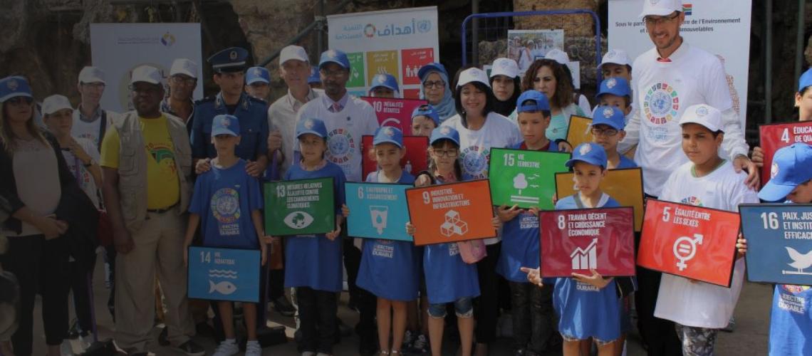 年轻人社区与联合国工作人员一起庆祝纳尔逊·曼德拉国际日。他们各自拿着可持续发展目标的标志。
