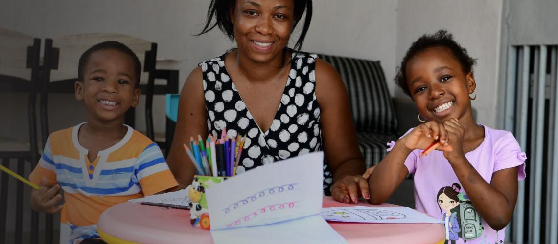 Una madre ayuda a sus niños y niñas a dibujar, en su casa de Abiyán.