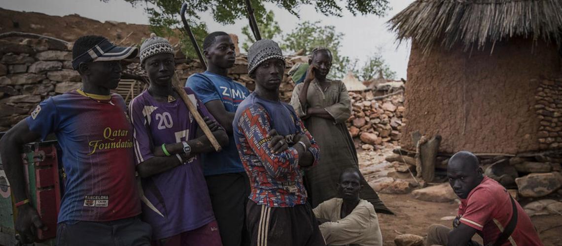 Young men from the region of Mopti stand outside their community.