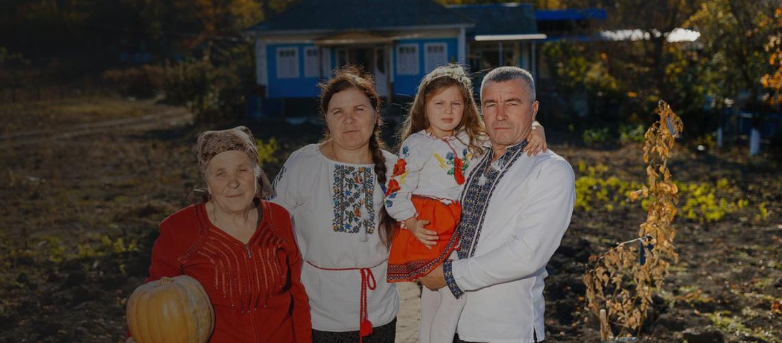 Una familia frente a su hermosa casa en Moldova.