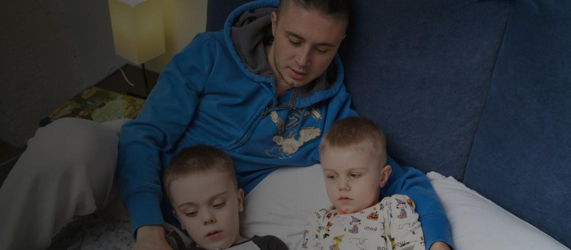 Ukrainian singer Taras Topolya reads a book to his sons.