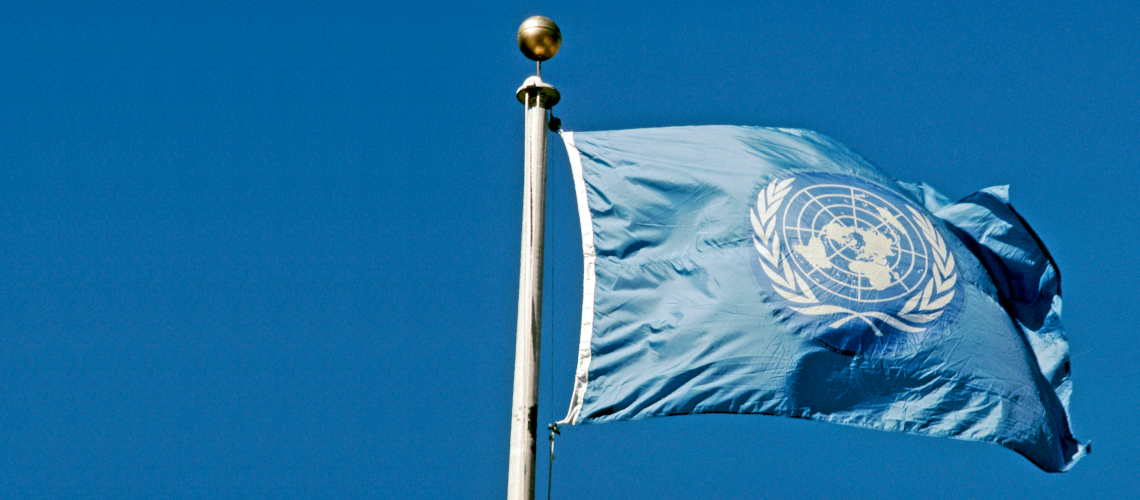 يرفرف علم الأمم المتحدة تحت سماء زرقاء لامعة.
