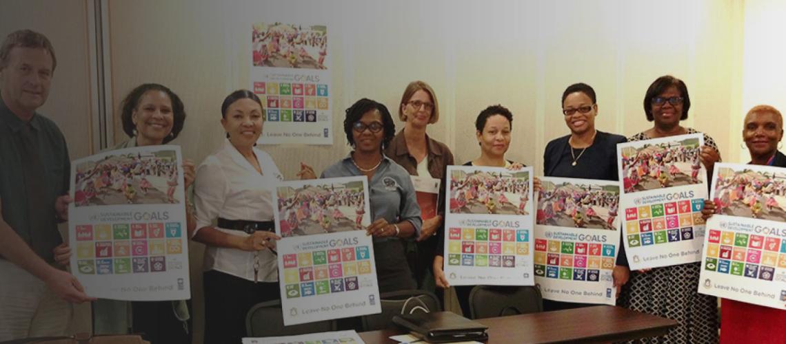 Representatives of school boards, managers, the USM and Program Manager, Drs. Loekie Morales holding the Sint Maarten SDGs Posters. 