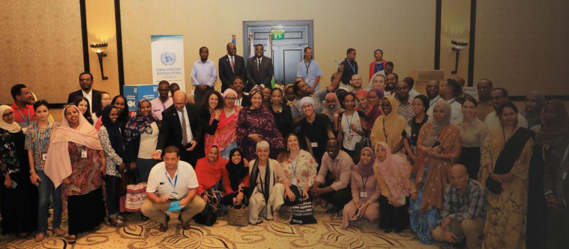 تقف نائبة الأمين العام أمينة محمد مع عدد من الموظفين لالتقاط صورة جماعية في دار الأمم المتحدة في جيبوتي.