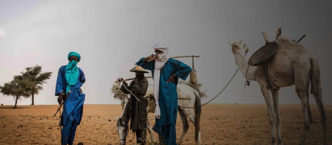رجال ونساء في حقل صحراوي مع جمل وحصان.