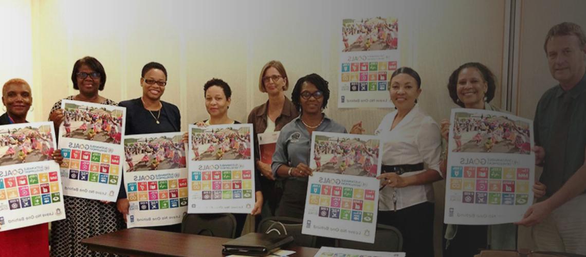 ممثلو مجالس المدارس والمدراء، ومدير برنامج USM د. لويكي موراليس يحملون ملصقات أهداف التنمية المستدامة في سنت مارتن.