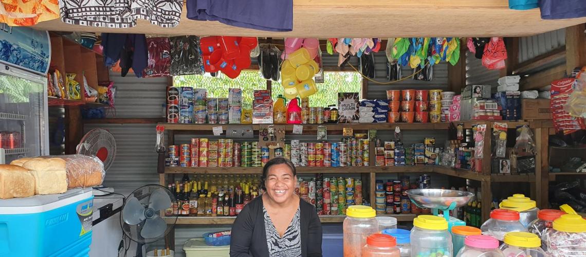 A woman vendor in a shop smiles