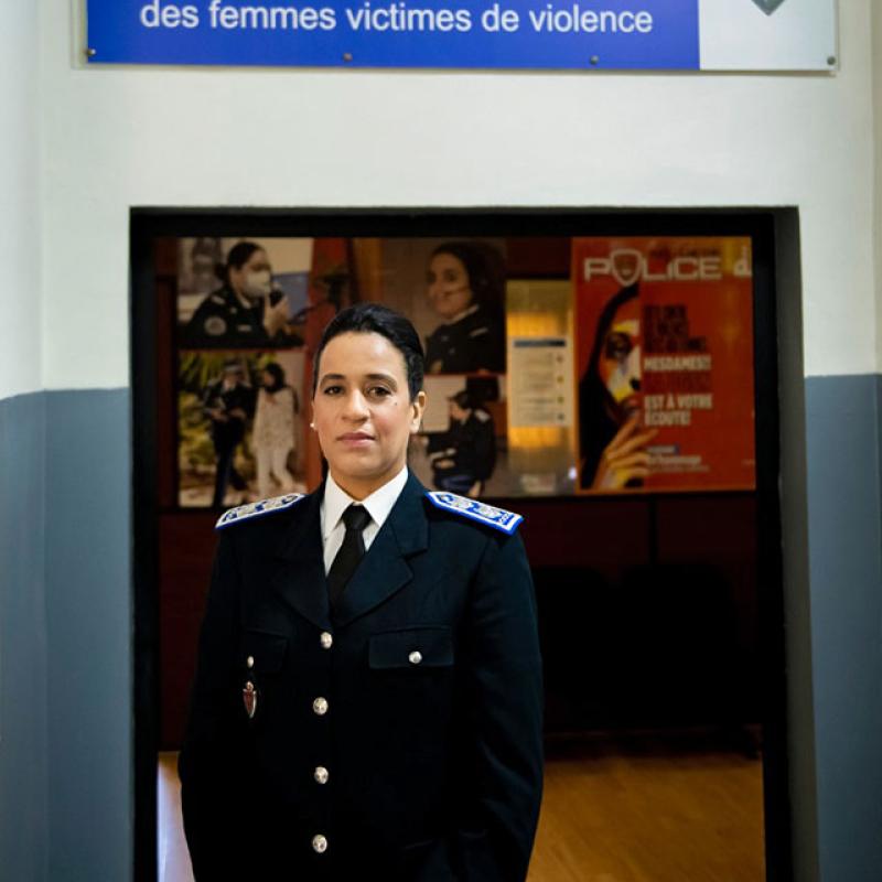 امرأة ترتدي زي الشرطة وتقف أمام باب المركز.